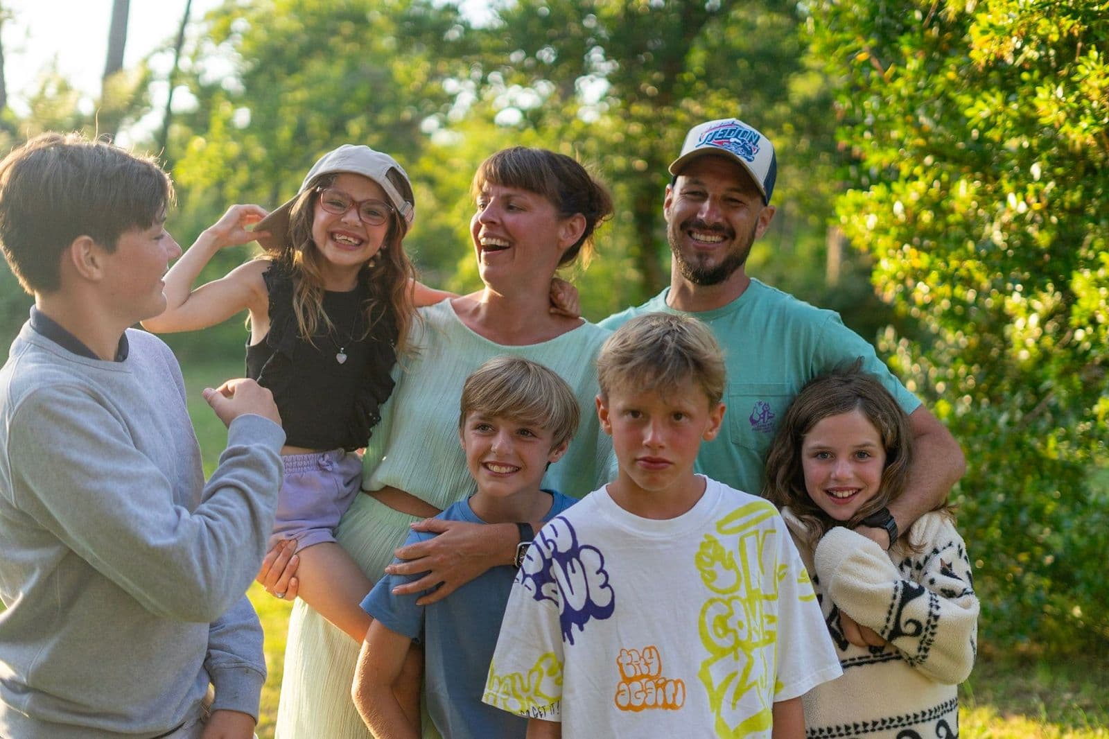 Een familie met mama, papa en 5 kinderen. Ze lachen naar elkaar